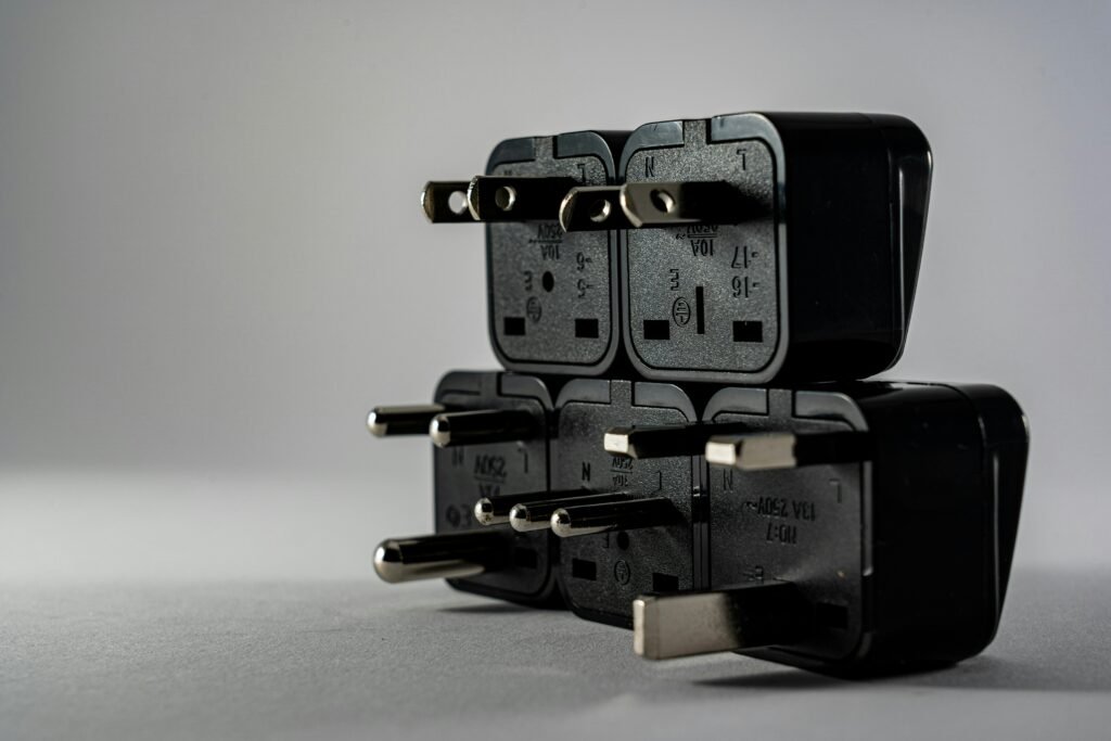 Close-up of black electrical adapters stacked on a gray background.